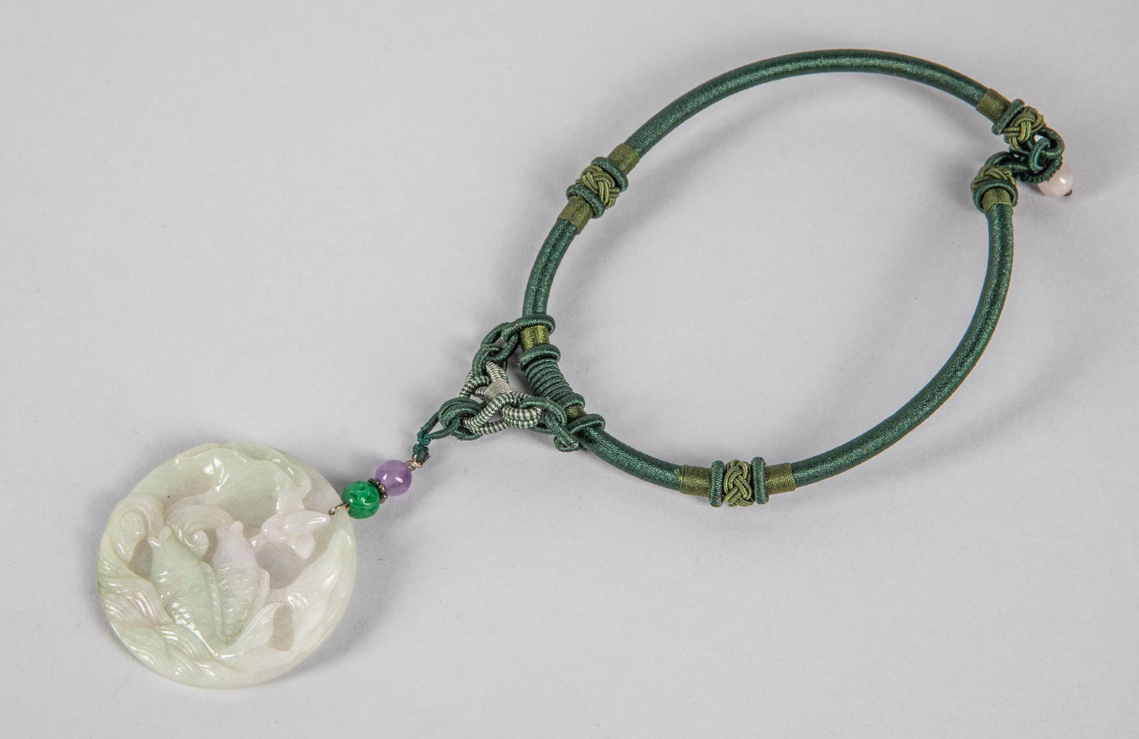 Chinese Jadeite Carving: Chinese jadeite carving pendant, a green jadeite beads & an amethyst beads suspended on the top. 2 inch D.