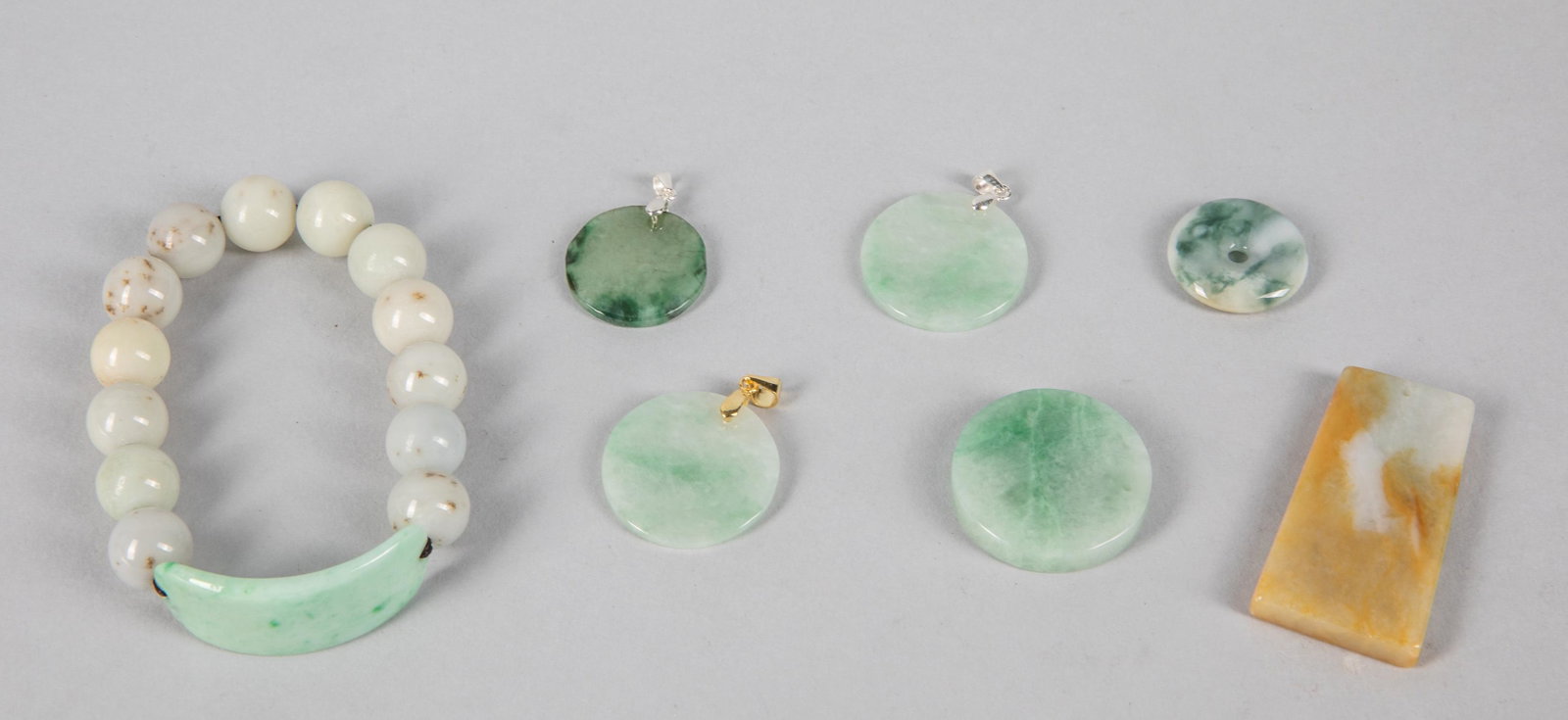 Group of Chinese Jadeite Carvings: Group of Chinese jadeite carvings including pendant & beads. 1.75 inch L. (the yellow color pendant).