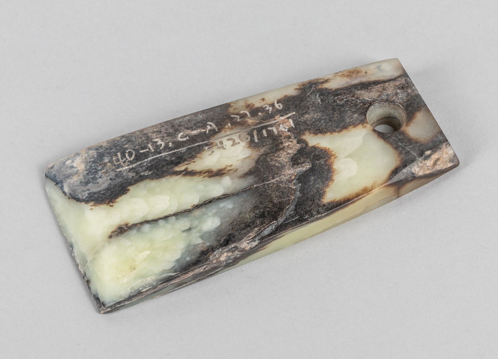 Chinese Jade Carving: Chinese jade carving, carved in the form of an archaistic tool, and a circular aperture at the top. The estate of the Choi Hoo King, HK. (1930-2005). 2.25-4.75 inch.