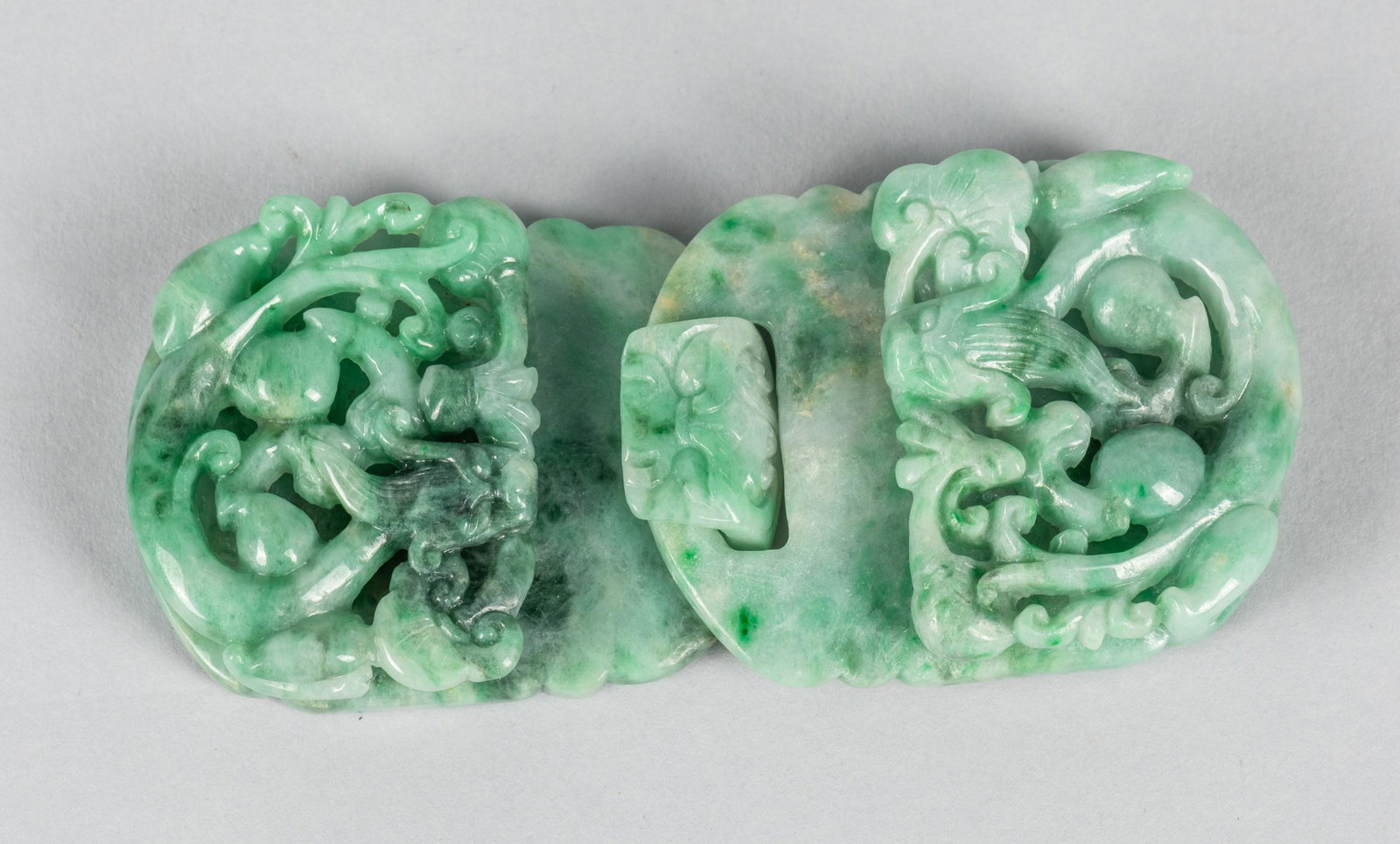 Chinese Jadeite Carving of Belt Buckle: Chinese jadeite carving belt buckle, decorated with lotus holding ruyi. 3.75 inch L; 1.6 inch W.