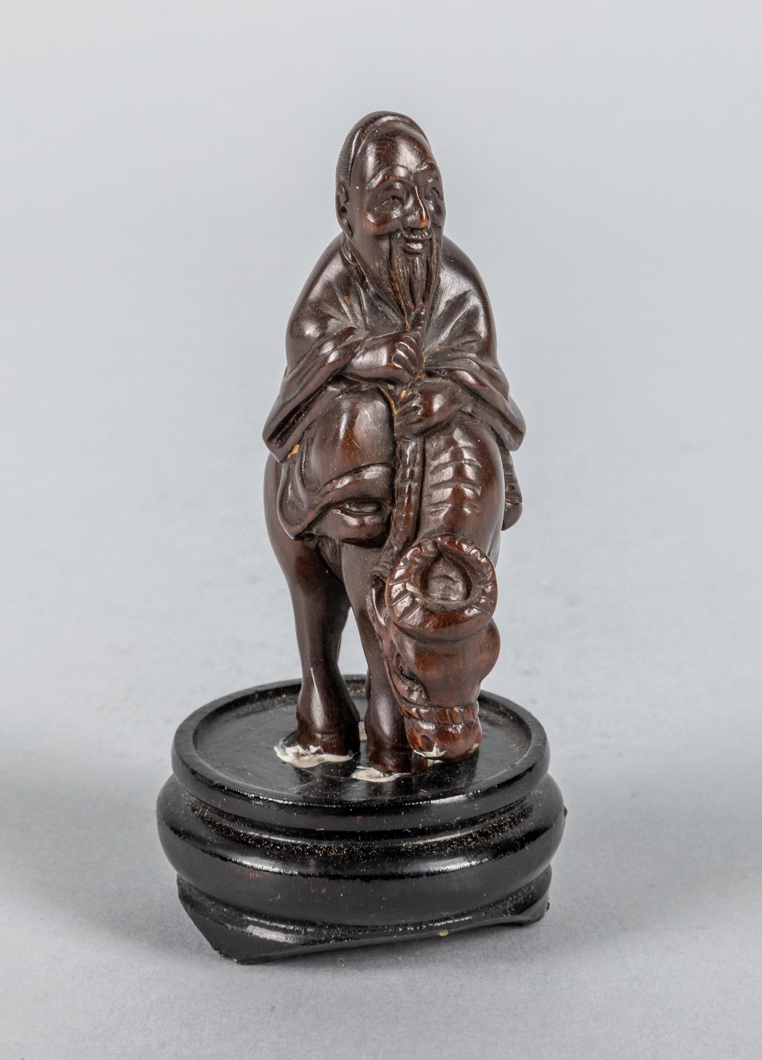 Japanese Signed Wood Carving Netsuke: Signed wood carving netsuke, man riding on a ox. 1.5 inch W; 2.75 inch H.