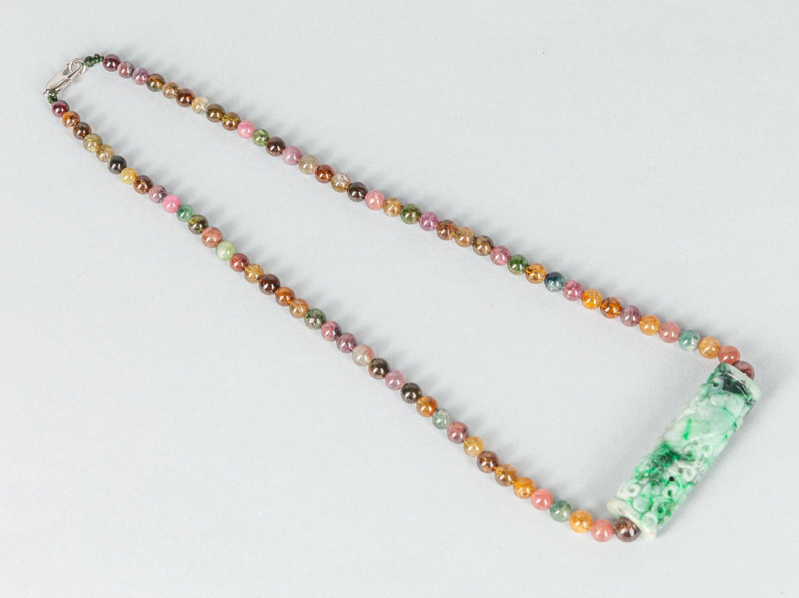 Chinese Jadeite Carving with Tourmaline Necklace: Nice detailed jadeite carving of Ruyi type pendant, suspended with colorful tourmaline beads necklace. 19 inch L.