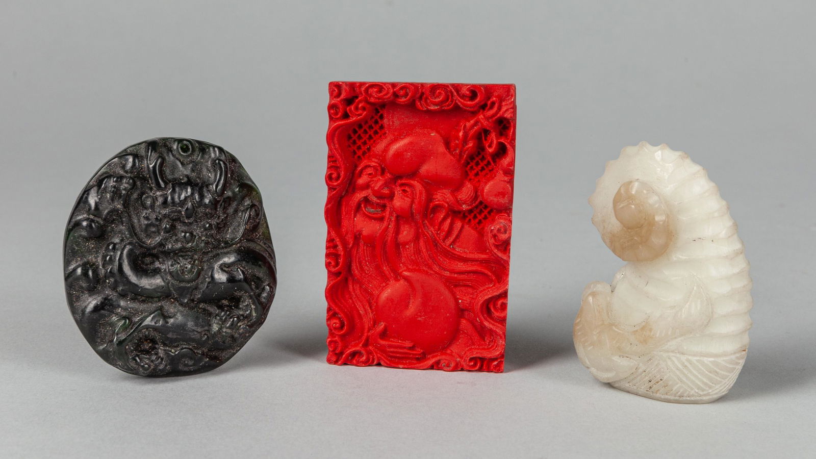 Set Chinese Export Jade and Stone Carvings: Set of three export Chinese Carvings, two pendants with carved shoulao and dragon, one jade carving. 2.25x1 inch.