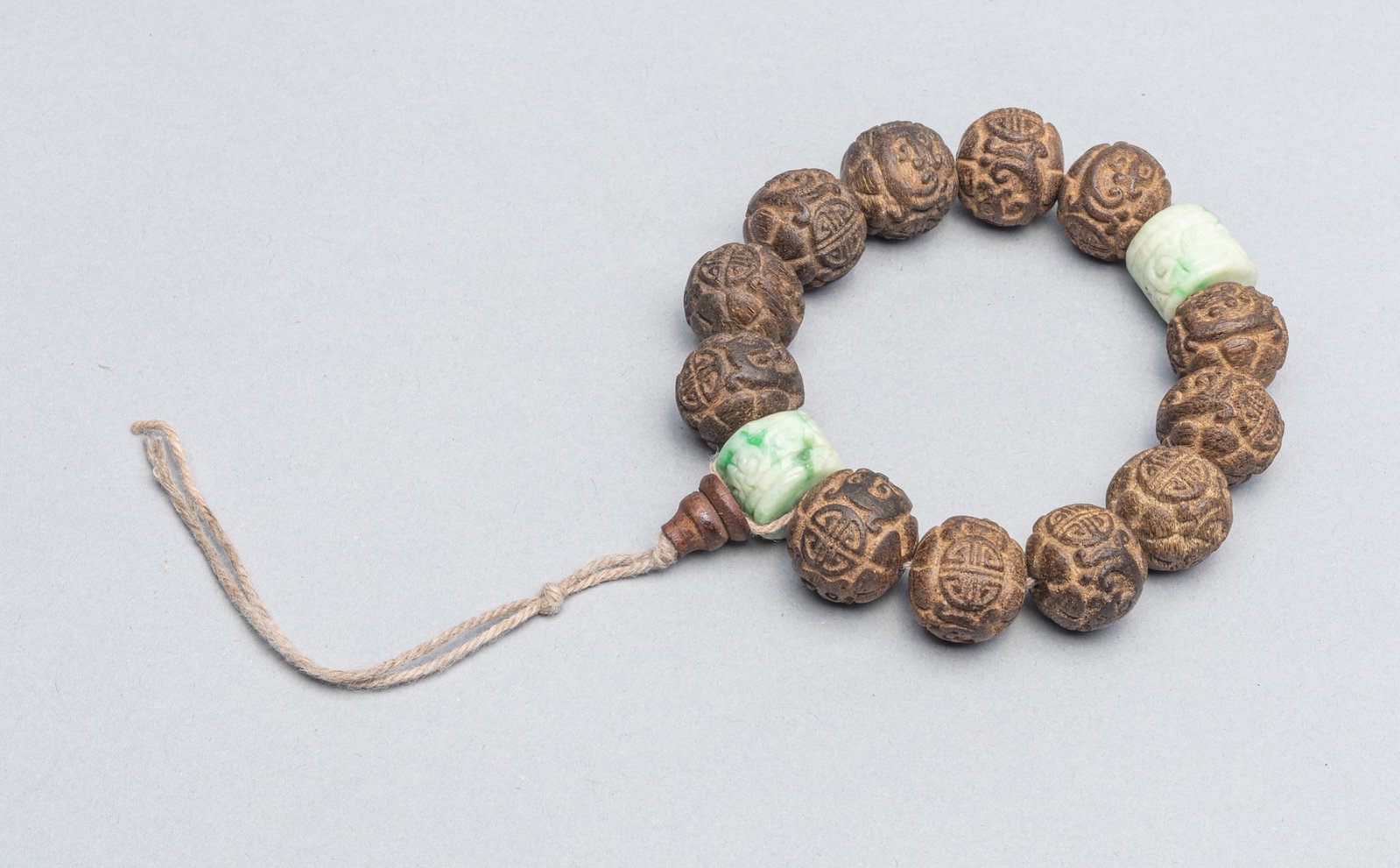 Chinese Export Agarwood Prayer Beads: Collectible Chinese export 12 large agarwood prayer beads spaced by two carved jadeite beads. 0.74 inch L (largest beads). The Estate of the Yaotome, Long Beach, CA, 2000.