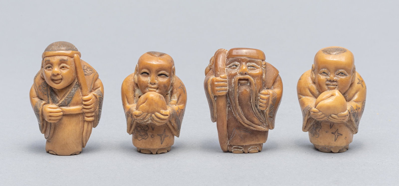 Set Japanese Taisho Type Vegetable-Ivory Netsuke: Collection of four Vegetable-Ivory Netsuke carved figures. Decorated with figures holding peach or crutch1.25x0.8 inch.