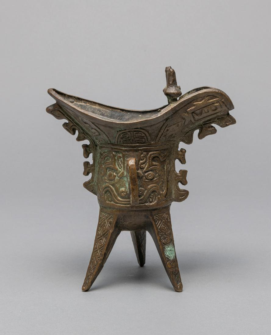 Chinese Bronze Tall Cup: Chinese bronze tall cup with deep U-shaped body raised on three sharp blade-shaped legs. 6.5*4.5*7 inch.