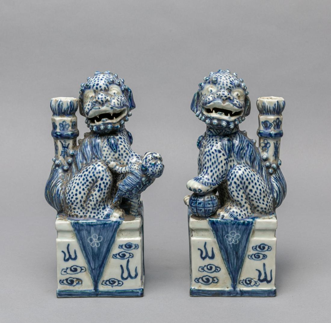 Pairs Japanese Taisho Period Blue White Porcelain: A pair of two Japanese taisho period blue and white porcelain foo dogs candle sticks, the male with a brocade ball under his left paw, and the female with a small cub. 3*3.7*8.25 inch.