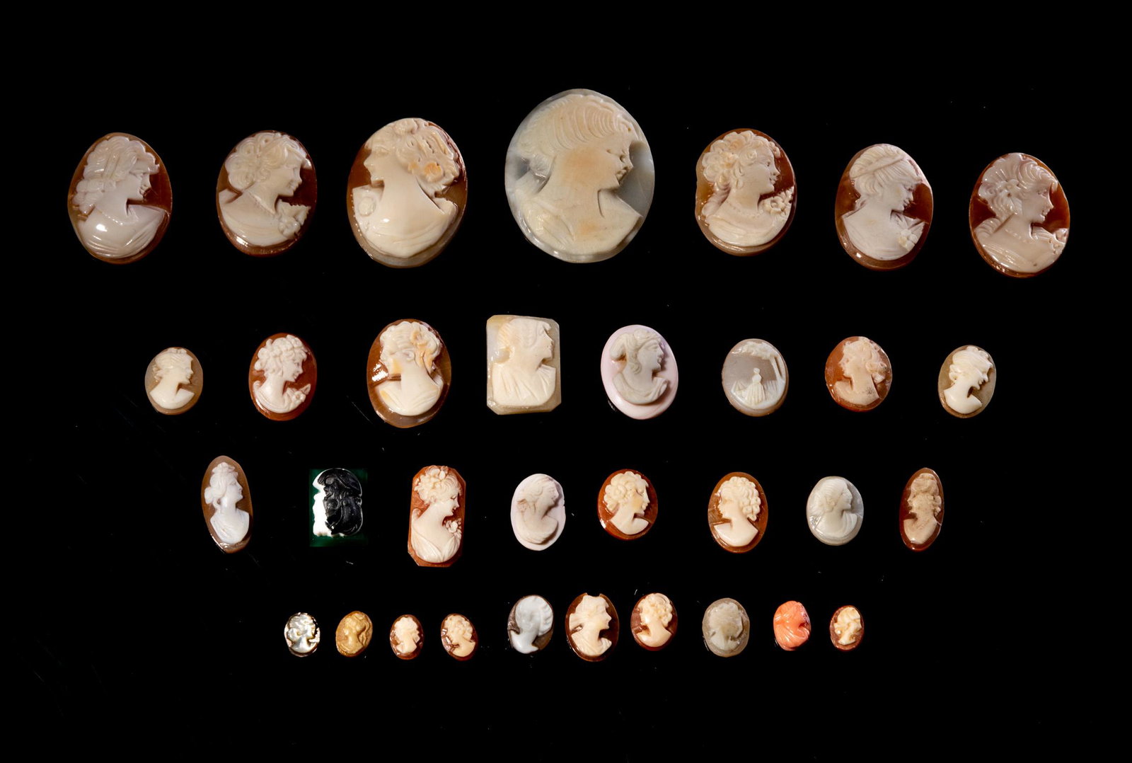Large Group of Victoria Type Cameo Carvings: The relief cameo image was of a contrasting color to the background; all achieved by carefully carving material with a flat plane where two contrasting colors met, removing all the first color except 