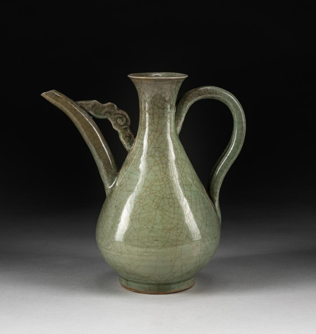 Korean Joseon Type Celadon Ewer: The well balanced pear shaped body rising from a straight foot to a slender neck and an everted mouth rim, set on one side with a tall curved tubular spout joined to the neck by a moulded cloud shaped