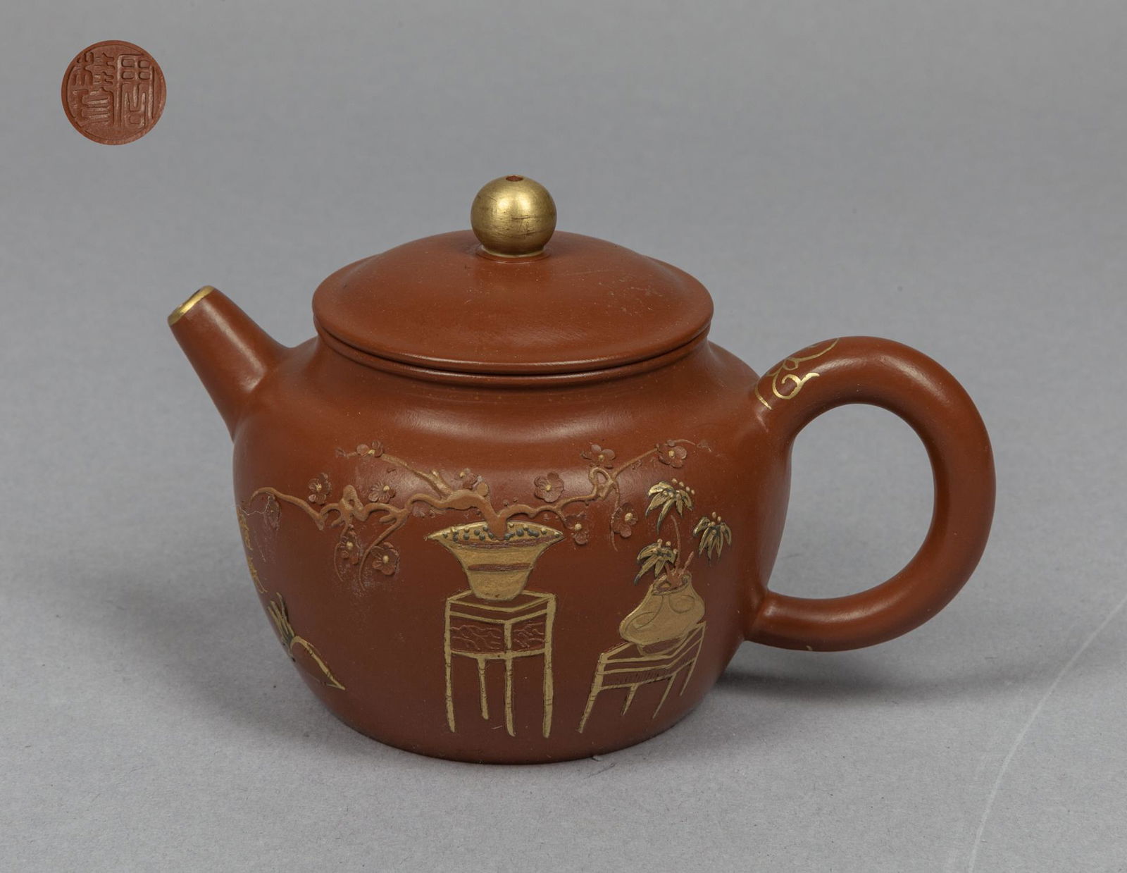 Chinese Gold Color Zisha Tea Pot: Carved with flowers in baskets on stands and fruit on the body, base incised with a mark, the cover, rim and handle decorated with gold color. 5*3.5*3.3inch.