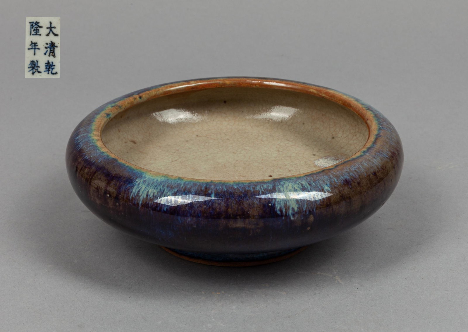 Chinese Flambe Glazed Porcelain Brush Washer: The exterior covered with deep purple flambe glaze with splashes of bluish lavender, the interior with gray celadon glaze, base with a six-character mark. 6.1*2inch.