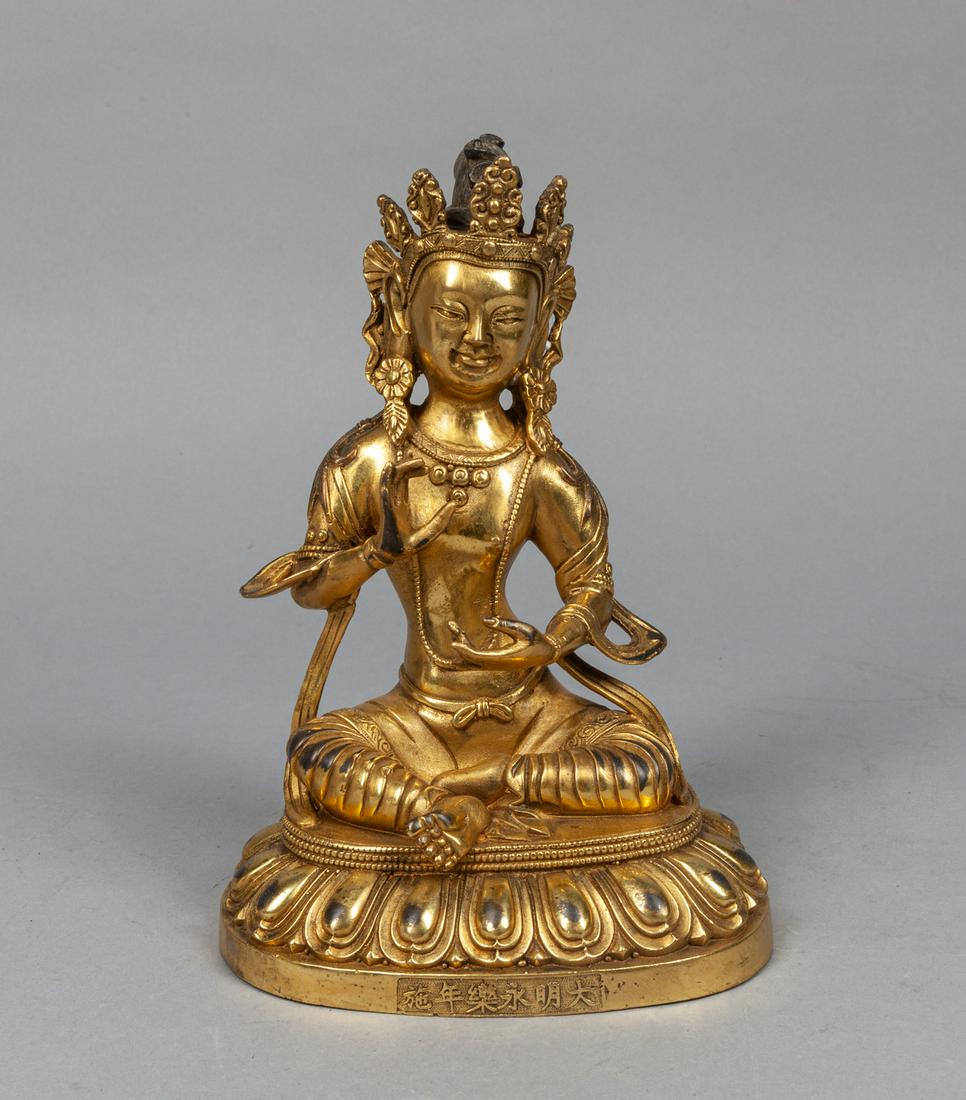 Chinese Gilt Bronze Buddha: Chinese gilt bronze buddha, seated on a lotus pedal base, wearing a petaled crown, pendant earrings and body jewelry, with a dhoti and a scarf billowing around his elbows, the base carved with six cha