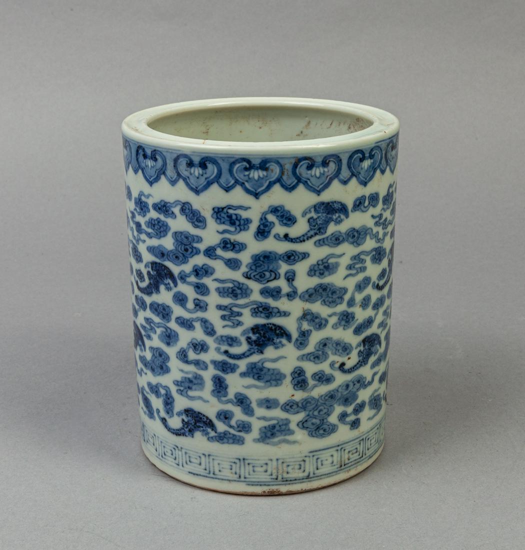 Chinese Blue White Porcelain Brush Pot: Of cylindrical form, the exterior painted with bats amidst dense clouds, beneath a band of ruyi and above a band of continuous key-fret motifs. 5.8*4.6inch. The Estate of the E Los Angeles, 2020.