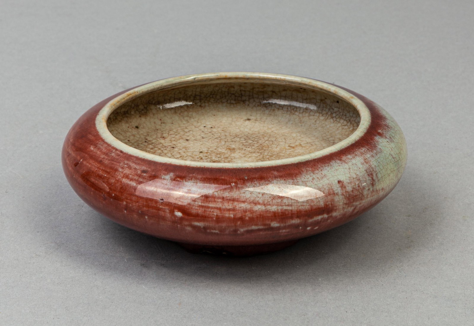 Chinese Flambe Glazed Porcelain Washer: The exterior covered with a streaked deep red glaze with celadon inclusions, the interior with celadon glaze with russet crackles. 5.3*1.7inch.
