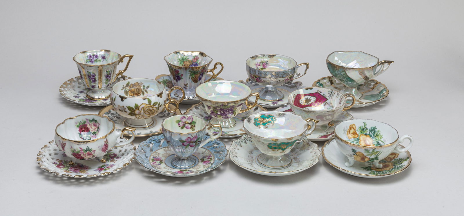 Set Enameled Porcelain Tea Cups: A large group of delicately enameled porcelain tea cups and saucers, decorated with flowers or fruits. 5.7*3.2inch (largest with stand).