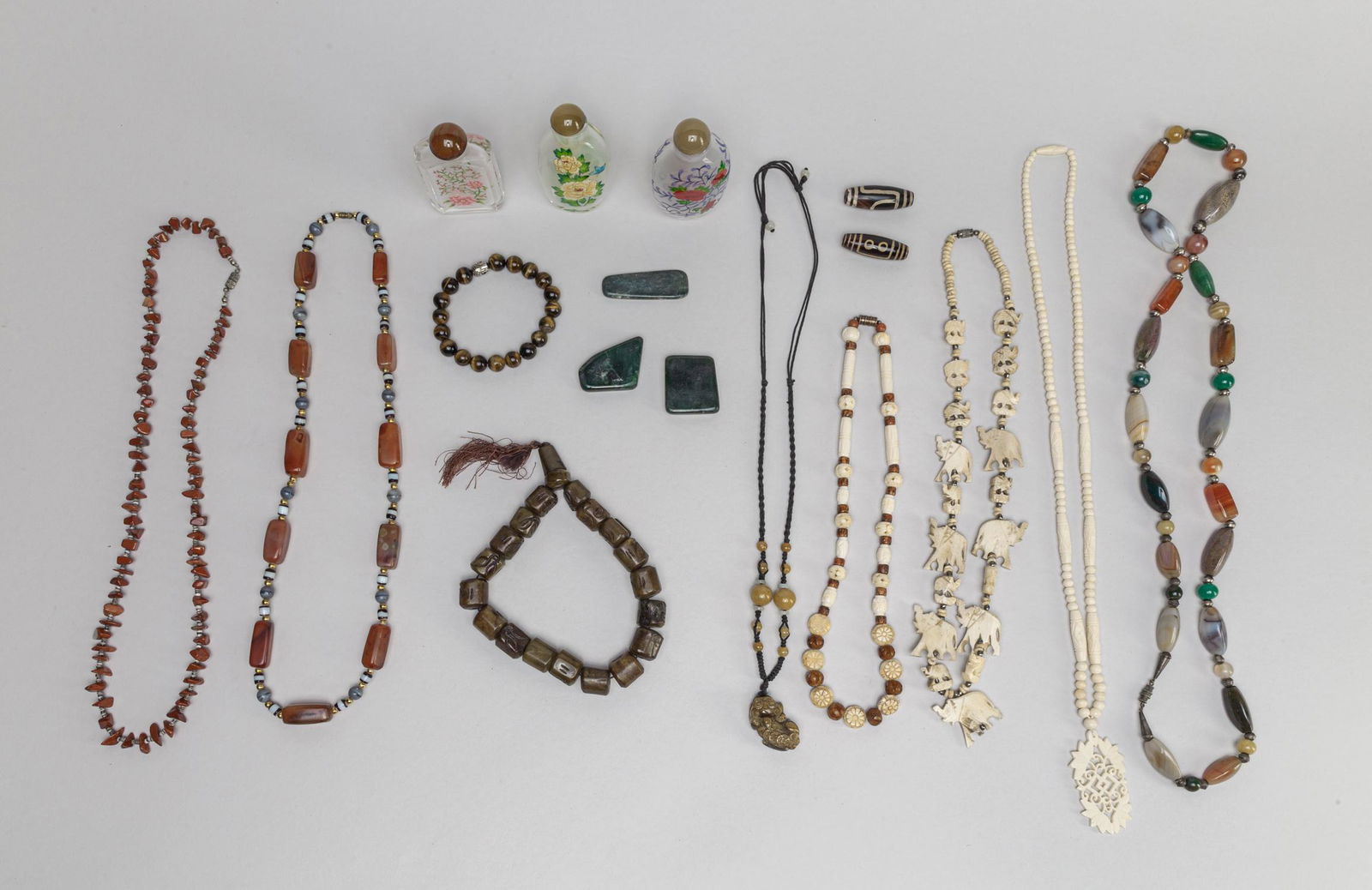 Group Estate Chinese Snuff Bottle/Beads: Including glass snuff bottles with stoppers, dzi beads, tiger eye stone bead bracelet, spinach jade carvings, and a large group of necklaces comprised of bone, wood, agate, jasper, tiger eye stone, ja