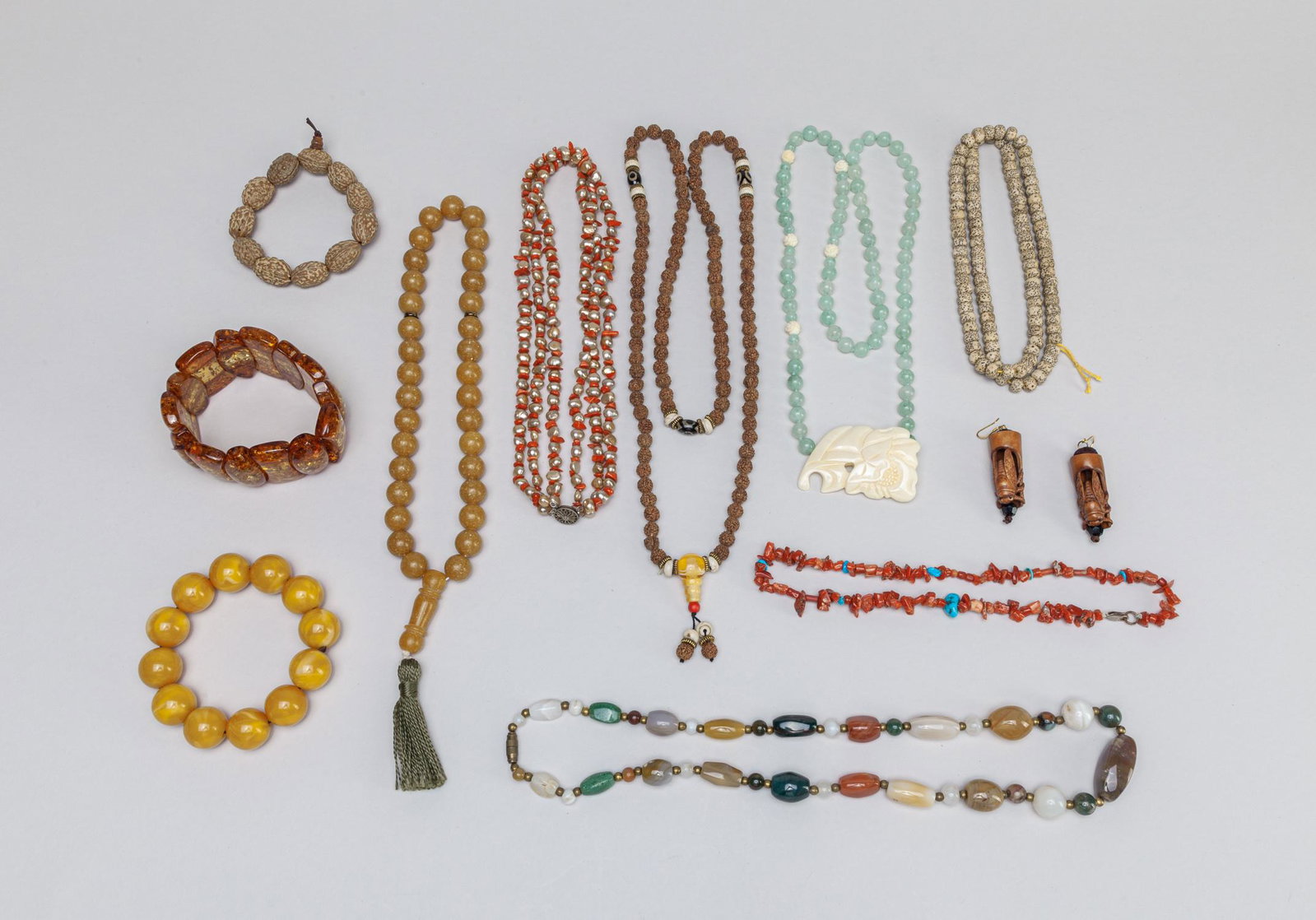 Estate Chinese Seed/Jade/Amber Like Jewelries: Including an agate necklace, a coral like and pearl necklace, a coral like and turquoise necklace, a jadeite like stone and bone necklace, two seed necklaces, a seed bracelet, three amber like bracele