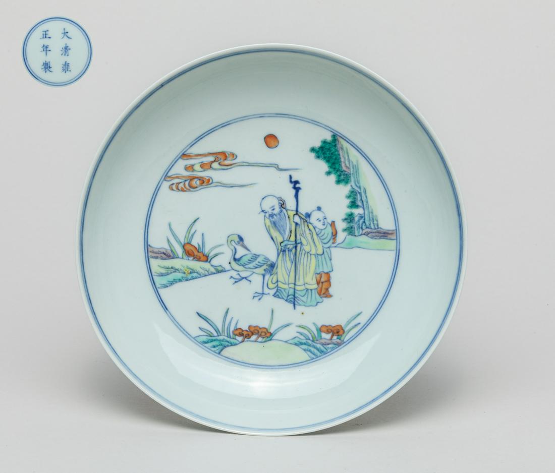 Chinese Doucai Porcelain Plate: The interior medallion painted with an old man and a child with a crane, lingzhi, clouds and sun, the exterior with flowers, base marked with six characters. 7.1inch D.