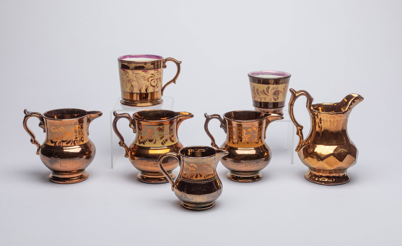 Sets Antique English Copper Luster Porcelain Wares: Including five creamers, a sugar bowl, and a cup, covered with a copper gold luster enamel to the exterior and painted with flowers. 5.8*4.5*3.6inch (largest).