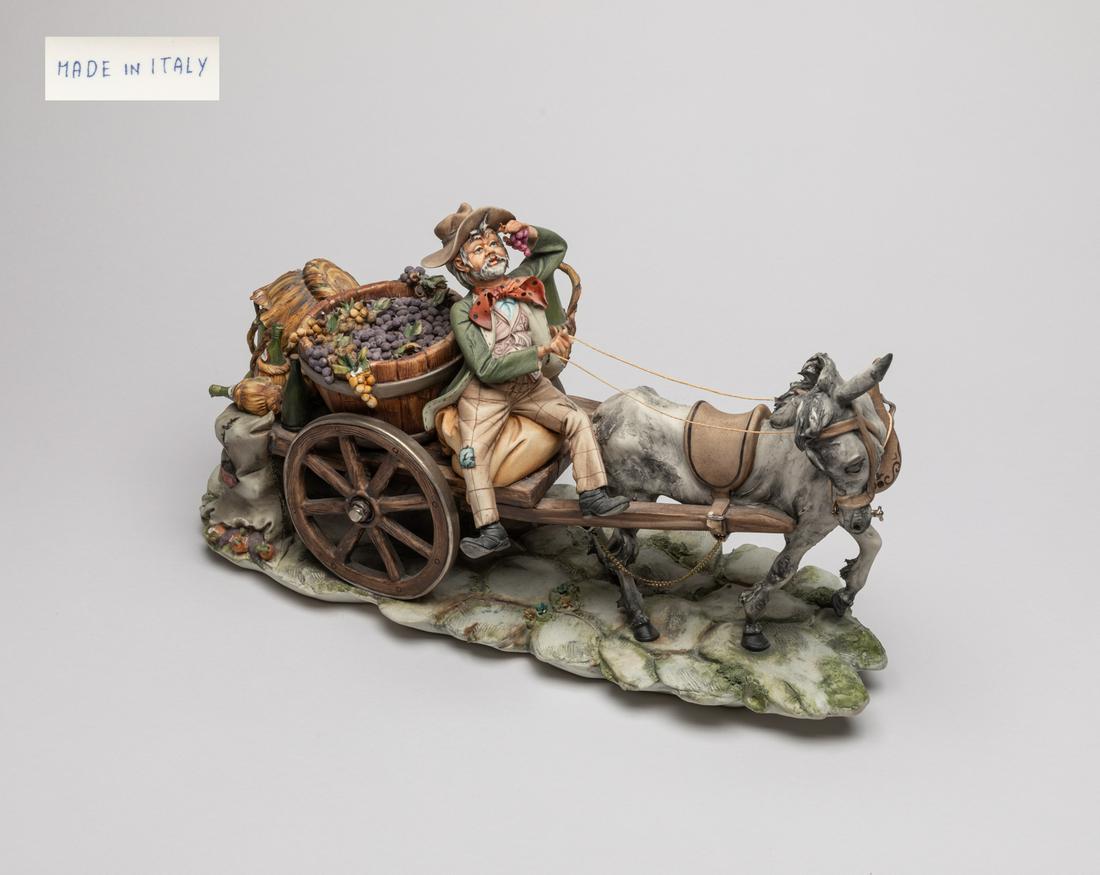 Italian Capodimonte Famille Rose Porcelain Sculpture: Decorative large Italy porcelain sculpture, finely designed as a figure riding a horse and cart with a basket of grapes and wine behind his back 15.5*8.3*6.3inch.