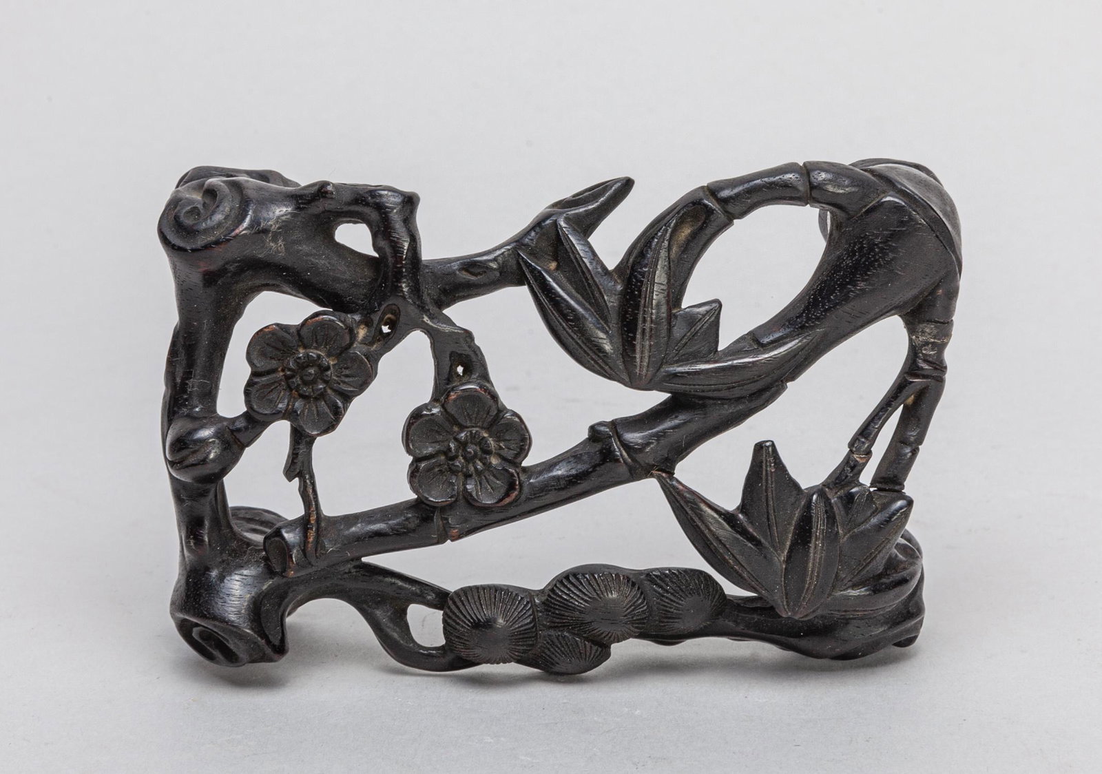 Chinese Zitan Like Wood Stand: Finely carved in openwork of bamboo, pine tree and plum blossoms stretching out to each other. 4*2.7*1.1inch.