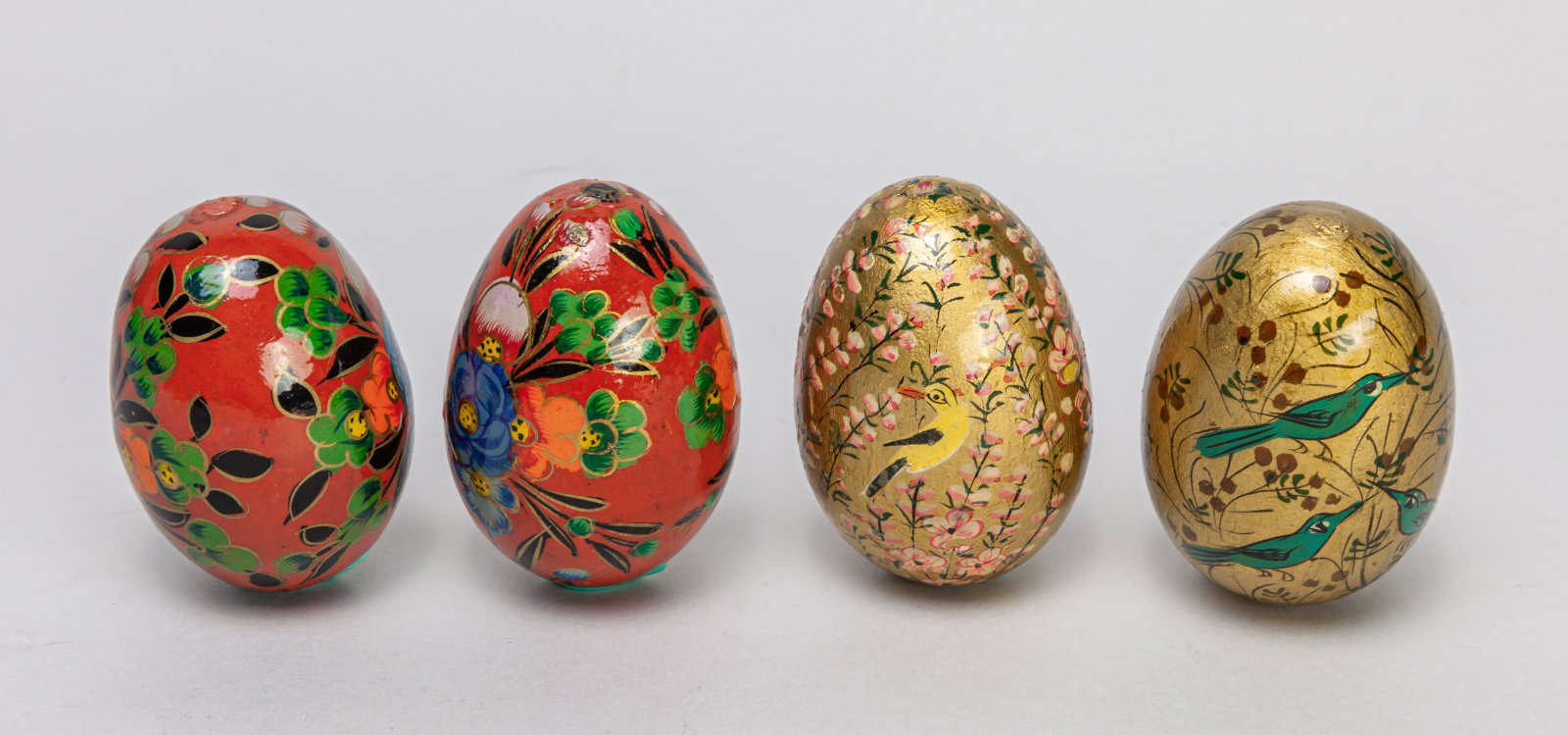 Set Japanese Taisho Enameled on Wood Egg Sculpture: Group of four collectible enameled wood eggs, two enameled with flowers on red ground, the other two with flowers and birds on golden ground. 2.8*1.9inch (largest).