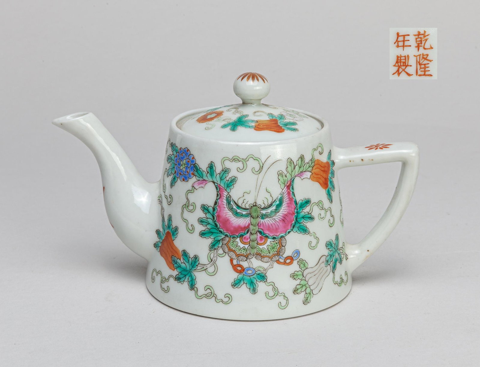 Chinese Famille Rose Porcelain Pot: Painted with butterflies, flowers and fruits around the body and cover, spout with a shou character, base with a four-character mark. 5.9*3.4*3.7inch.
