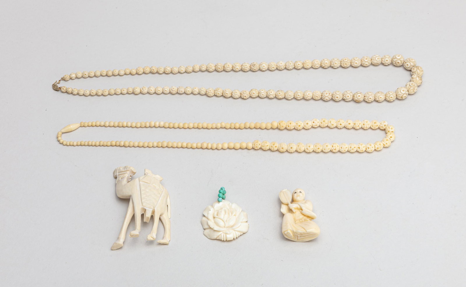 Japanese Bone Like Carvings: Group of bone like necklaces and carvings, carved in form of flower, figure or camel. 28inch L (largest).