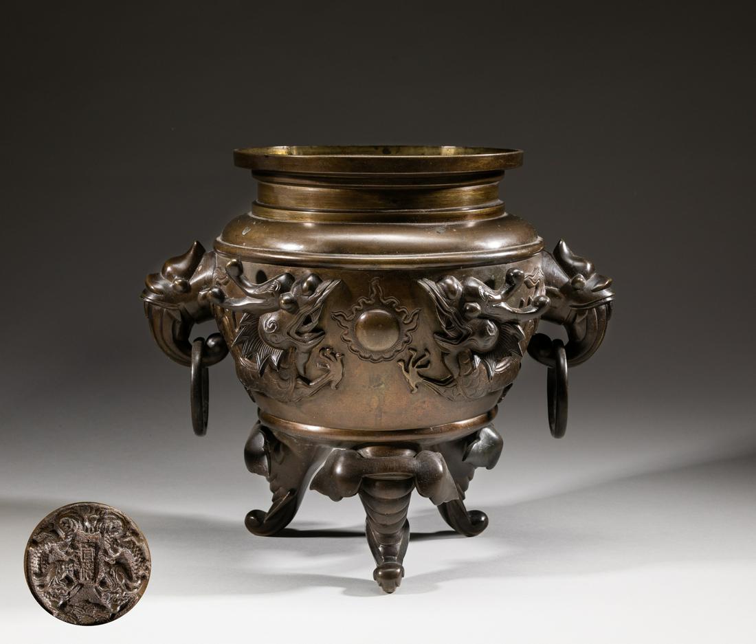 Japanese Antique Bronze Censer: The ovoid body casted in high relief with a pair of coiling ferocious dragons in pursuit of a flaming pearl, flanked with a pair of dragon ring handles, supported with three elephant type feet, base c