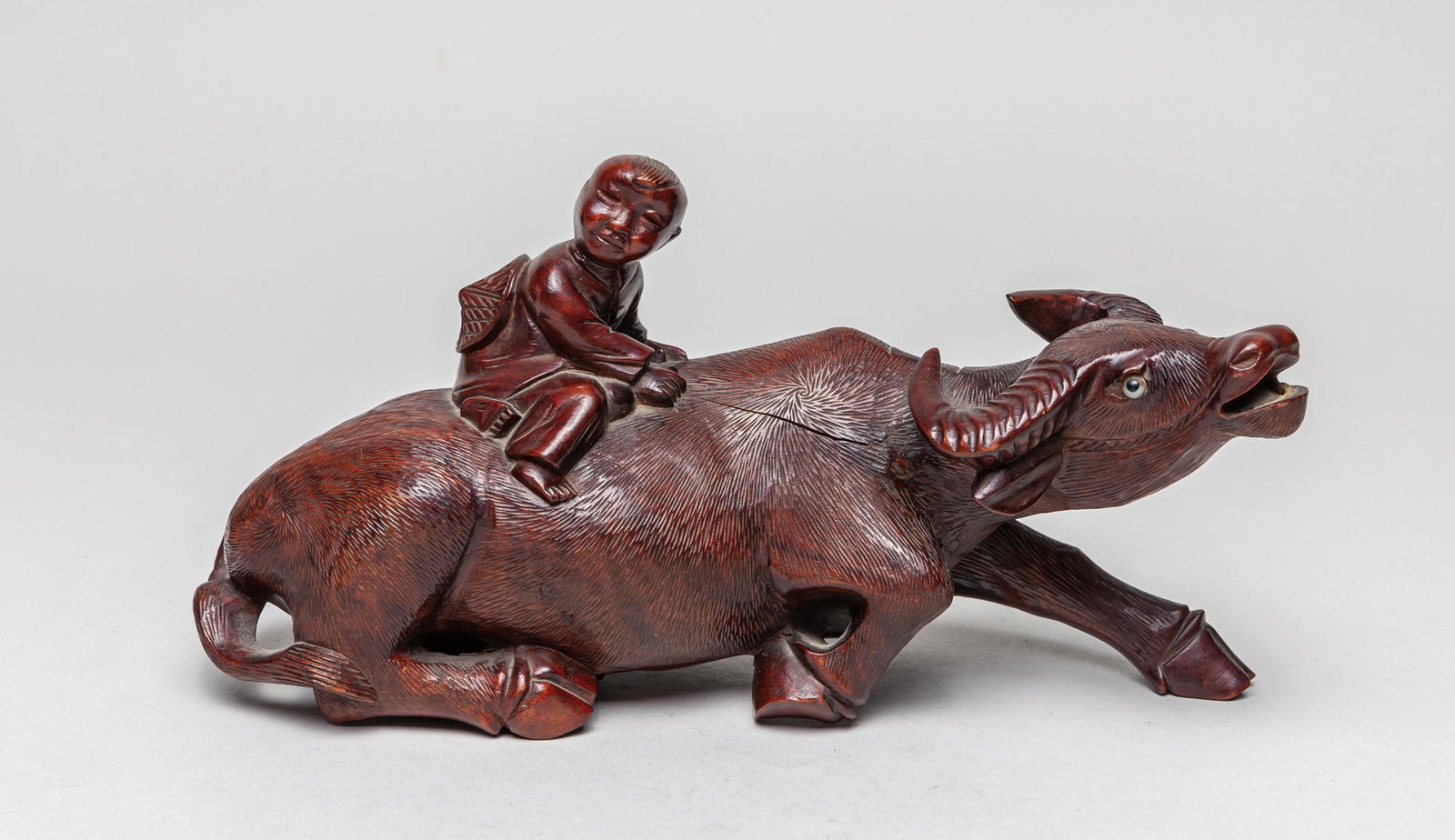 Antique Chinese Carved Rosewood Table Sculpture: Carved as a child seated on a crouching bull, both the heads of child and bull facing towards right. 5inch H, 9.7inch L, 3.3inch W.
