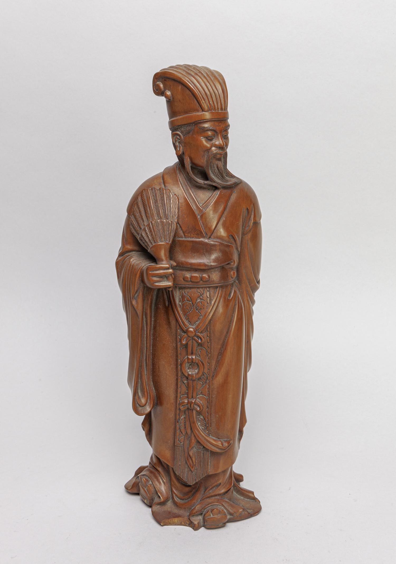 Chinese Boxwood Carved Figure of Man: Carved as an ancient Chinese man wearing a long robe and holding a feather fan. 13inch H, 4.4inch L, 3.5inch W.