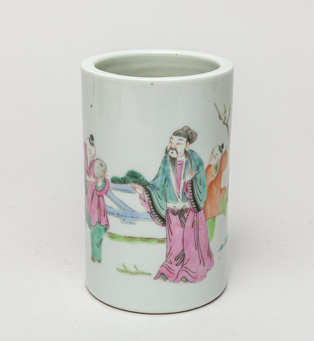 Chinese Famille Rose Porcelain Brush Pot: The cylindrical body painted to the exterior with three figures in various activities amid grass and rockery. 4.7inch D, 3inch H.