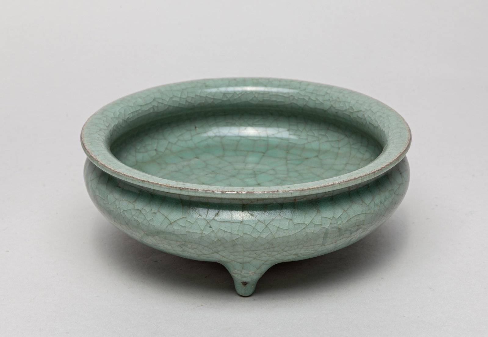 Collectible Chinese Longquan Type Porcelain Washer: The compressed globular body rising from a tapering foot to a short waisted neck and a flared rim, set the three feet, overall applied with a celadon glaze suffused with a network of crackles. 6.6inch