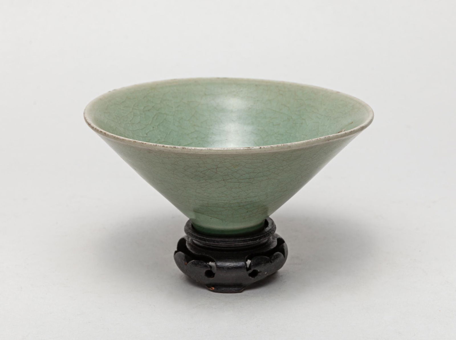 Chinese Sung Type Longquan Tea Cup: Collectible shipwreck type longquan tea cup of conical form with wide flaring sides rising from a narrow foot, applied overall with a soft grayish-celadon glaze suffused with a network of natural crac