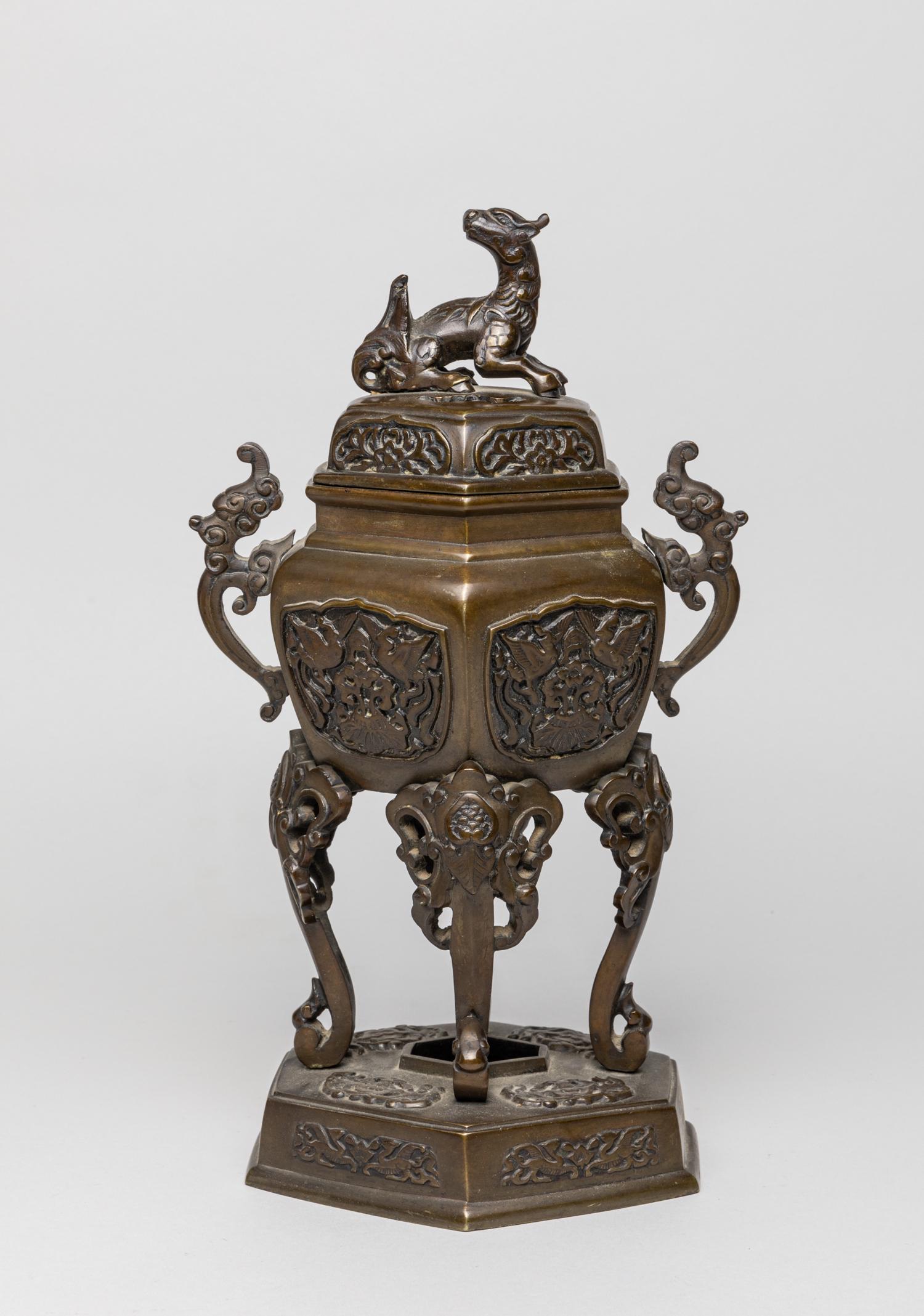 Collectible Chinese Bronze Censer: Of flattened hexagonal section, the sides carved with panels of pairs of cranes enclosing flowers, supported with four elephant type feet and a base carved with archaic beasts and birds, the cover cas