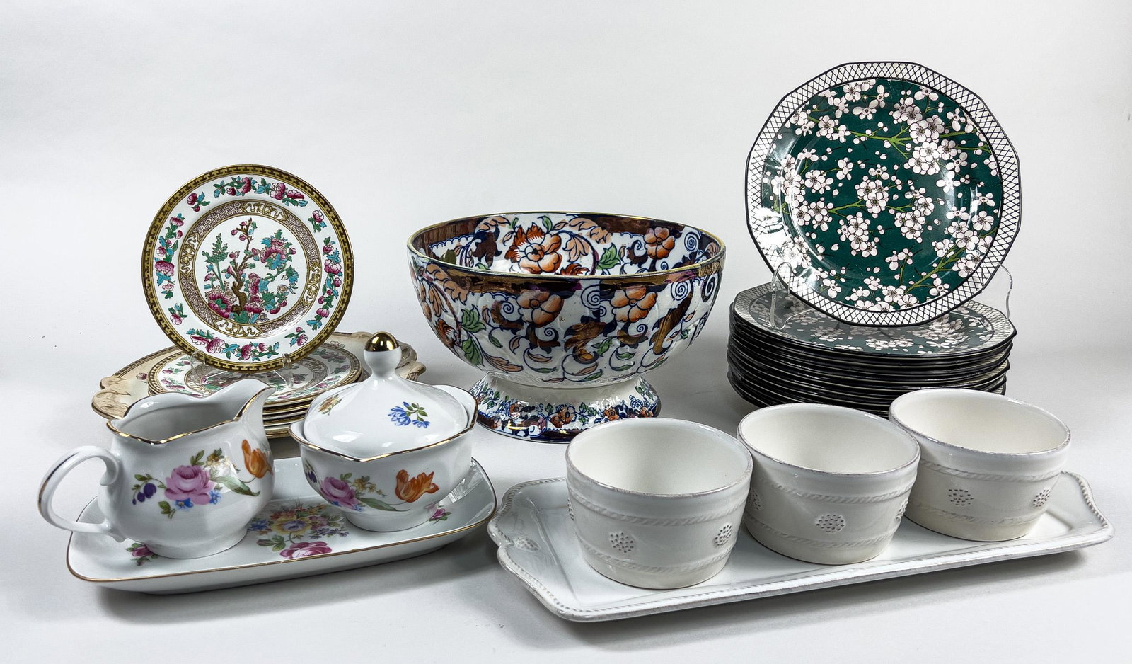 Collectible Porcelain Flat Wares: Including plates in various sizes, a centerpiece, a creamer and sugar bowl set with a tray, and three cups with a tray, decorated with stylized flower patterns. 9.5inch D, 5.5inch H (largest).