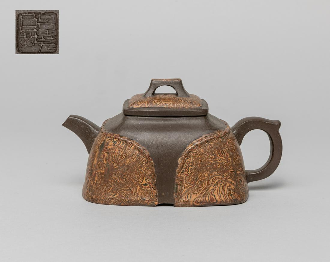 Collectible Chinese Yixing Zisha Tea Pot: The exterior decorated with reticular patterns, inside with two marks on the cover interior, a mark on the handle foot, and a seal mark at the base. 6inch L, 3.35inch W, 3.1inch H.