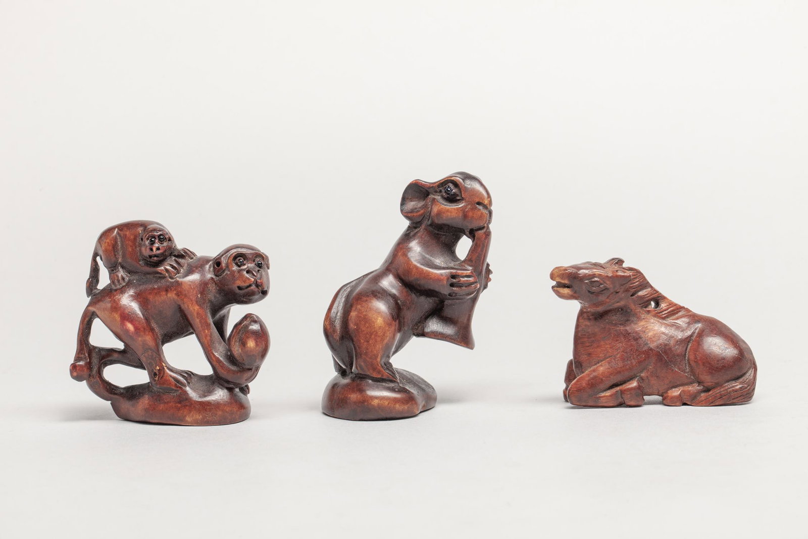 Collectible Japanese Root Wood Netsuke: Three as a group, deftly carved as recumbent horse, rabbit eating mushroom, and monkeys holding a peach. 2.55inch H, 1.6inch L, 1.26inch W (largest).