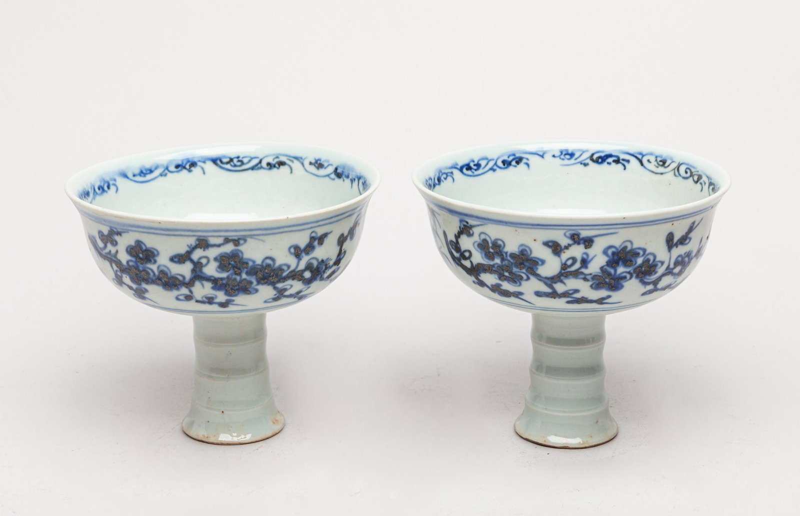Pair Korean Blue & White Tall Cups: The sides exterior painted with bamboo, plum blossoms and pine trees, the interior center with flowers, the gently splayed foot mould with three raised bands. 4.2inch H, 5inch D. The Estate of King Mi