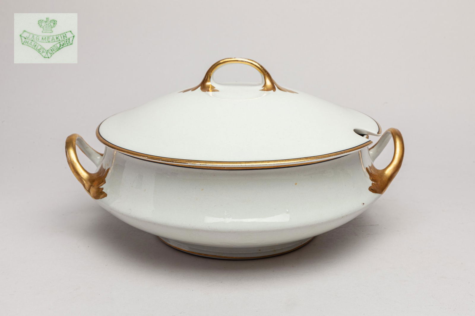England Hanley J & G Meakin Porcelain Bowl: Large English type porcelain central bowl, applied with an even white glaze with golden-colored handles, the base marked J&G Meakin Hanley England. 10.8inch L, 9.6inch W.