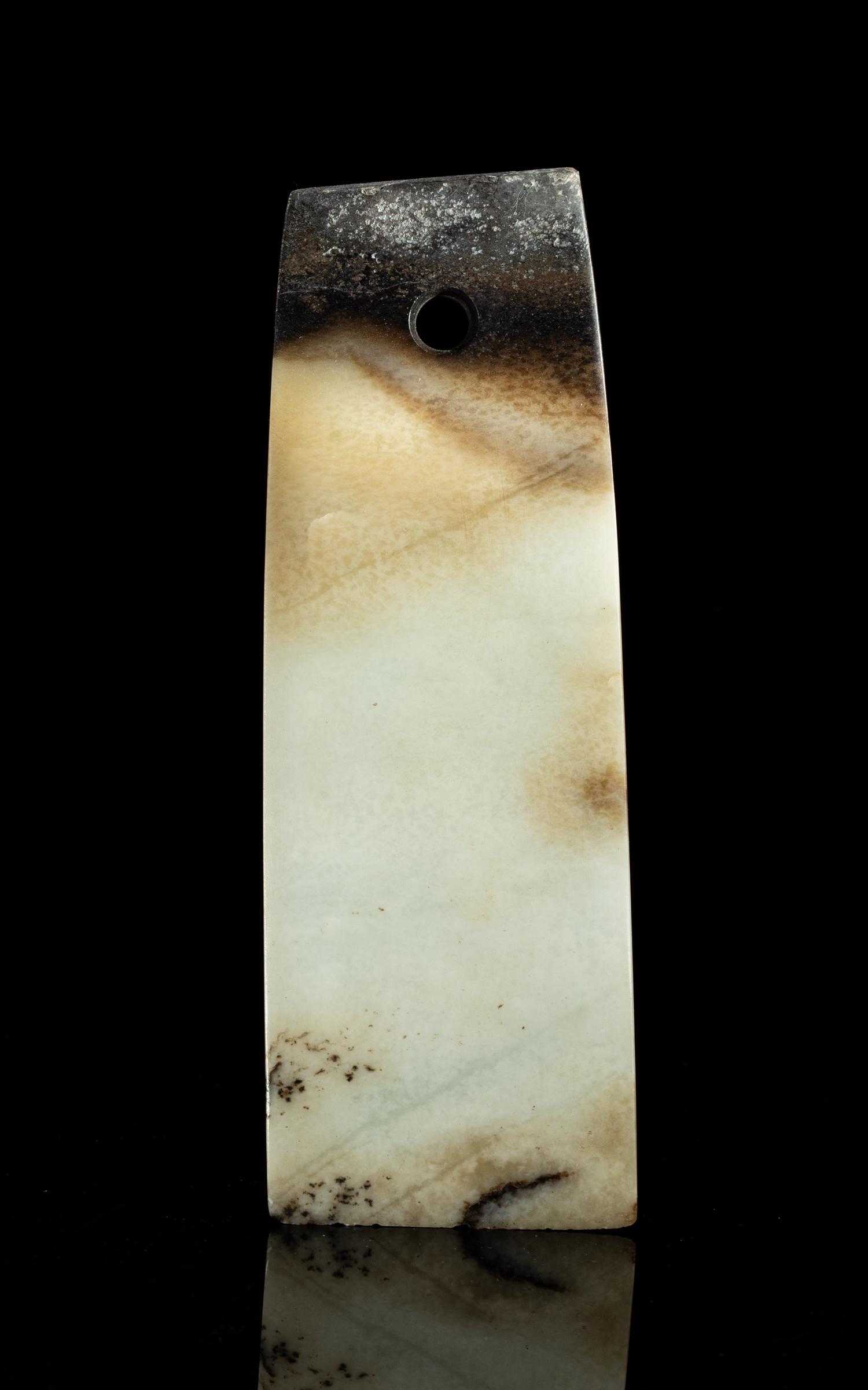 Chinese Jade Carving of Axe: Of flaring form with a gently bevelled rounded cutting edge, the opposite end pierced through with a hole, of translucent cream color with black inclusions and patches. 6.8inch L, 2.5 inch W. The Esta