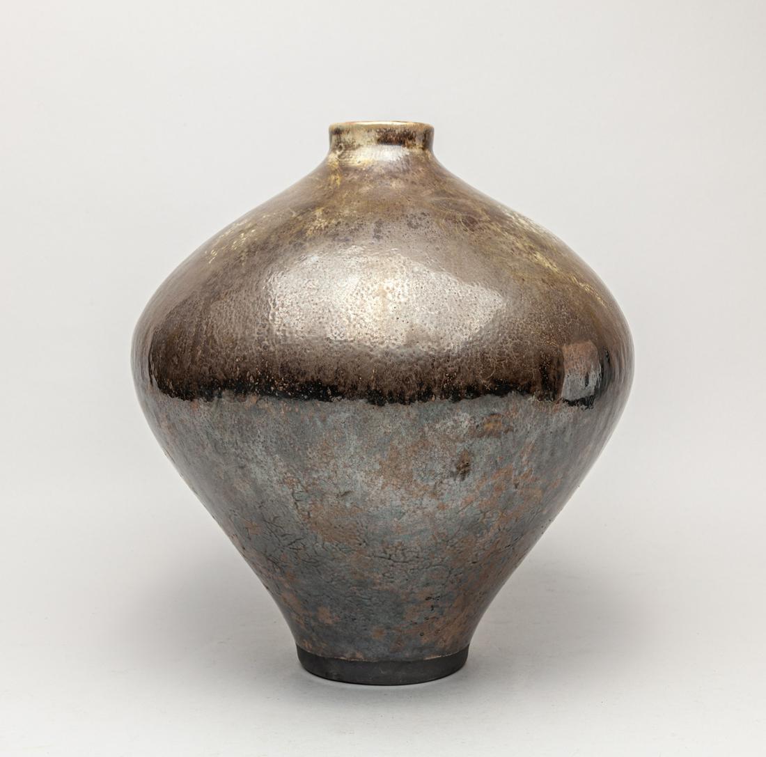 Hand-Thrown Raku Type Pottery Vase: The broad tapering body rising to a short neck, the exterior applied with a silver-colored glaze. 11.5inch H, 10.2inch W.