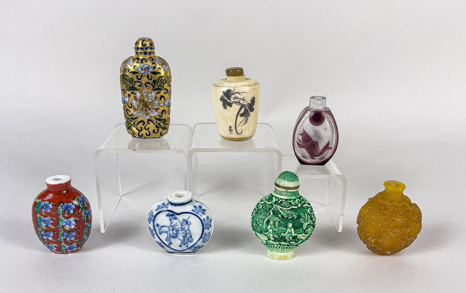 Collectible Chinese Snuff Bottles: Group of seven collectible snuff bottles, including two bone like carved with birds or figural scenes, two porcelain painted with flowers or figures, the overlay glass one designed with fish and pearl