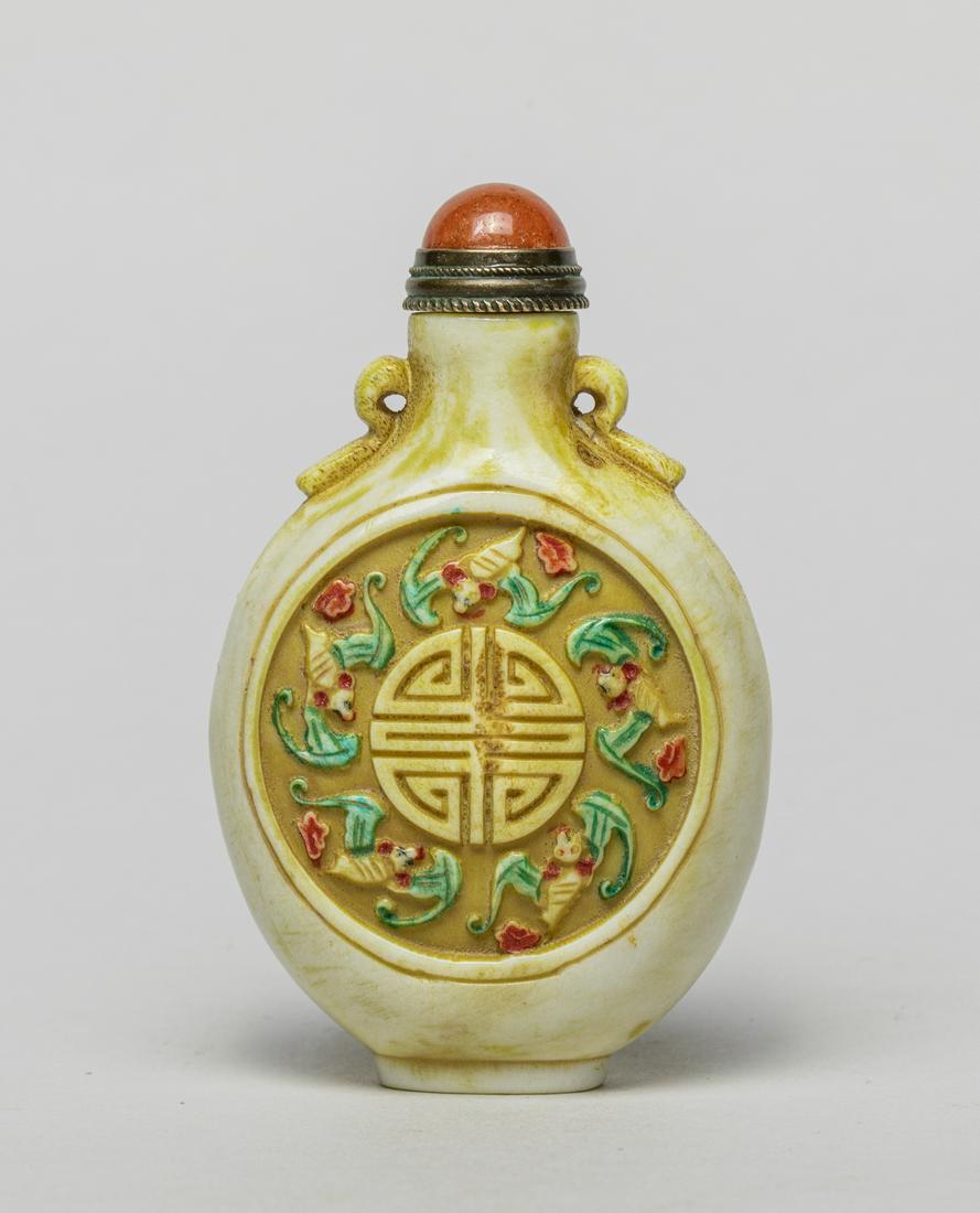 Vintage Chinese Bone Like Snuff Bottle: Modeled in flattened rounded form, either side carved with a circular panel enclosing five bats surrounding a stylized shou characters among clouds, the neck flanked by two pierced handles, with a gla
