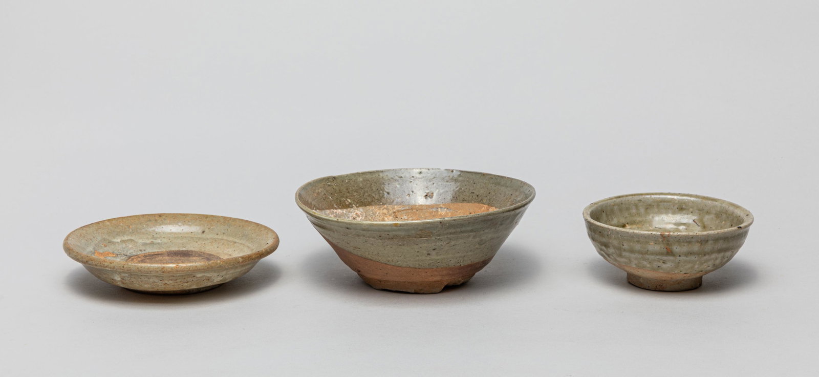 Chinese Yue Type Shipwreck Porcelains: Group of three Yue type shipwreck porcelain bowls, applied with mottled celadon glaze save for the foot or interior centre. 5.8inch W, 2.1inch H (largest).