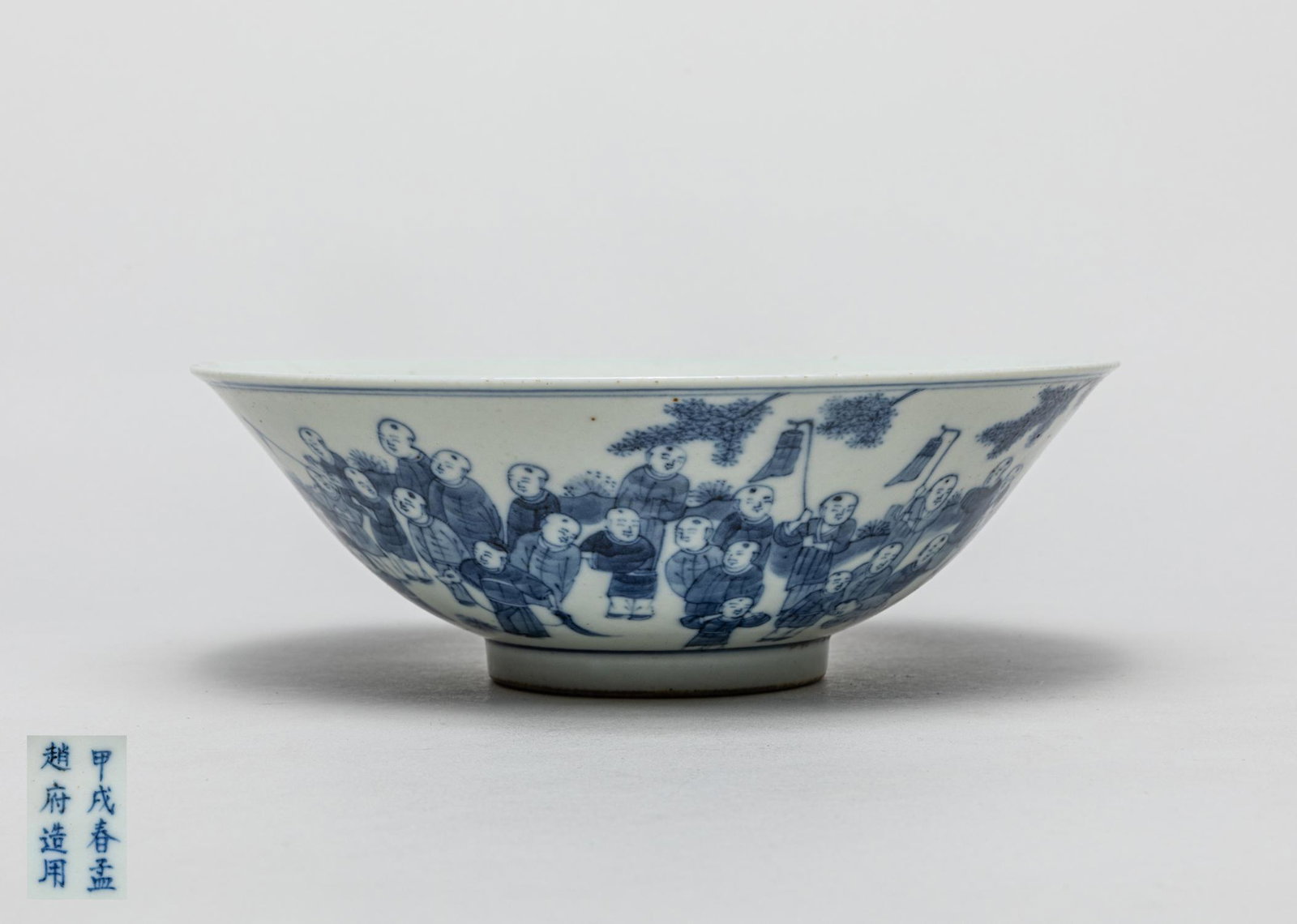 Large Chinese Blue & White Porcelain Bowl: The exterior painted with a continuous figural scene depicting boys in various activities, the interior centre with two boys in bow pose, the bottom inscribed with eight characters. 7.7inch W, 2.6inch