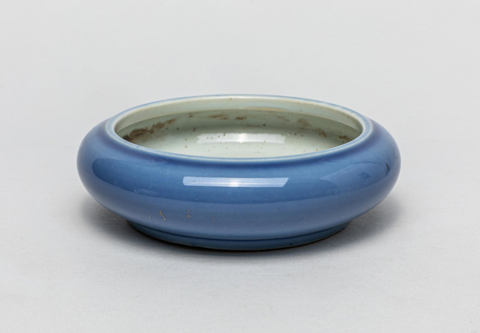 Chinese Blue Glazed Porcelain Brush Washer: Of compressed global form, the exterior covered with a lustrous blue glaze, the interior with a bubbled white glaze, the foot left unglazed to reveal the porcelain body. 5.1inch W, 1.5inch H. The Esta