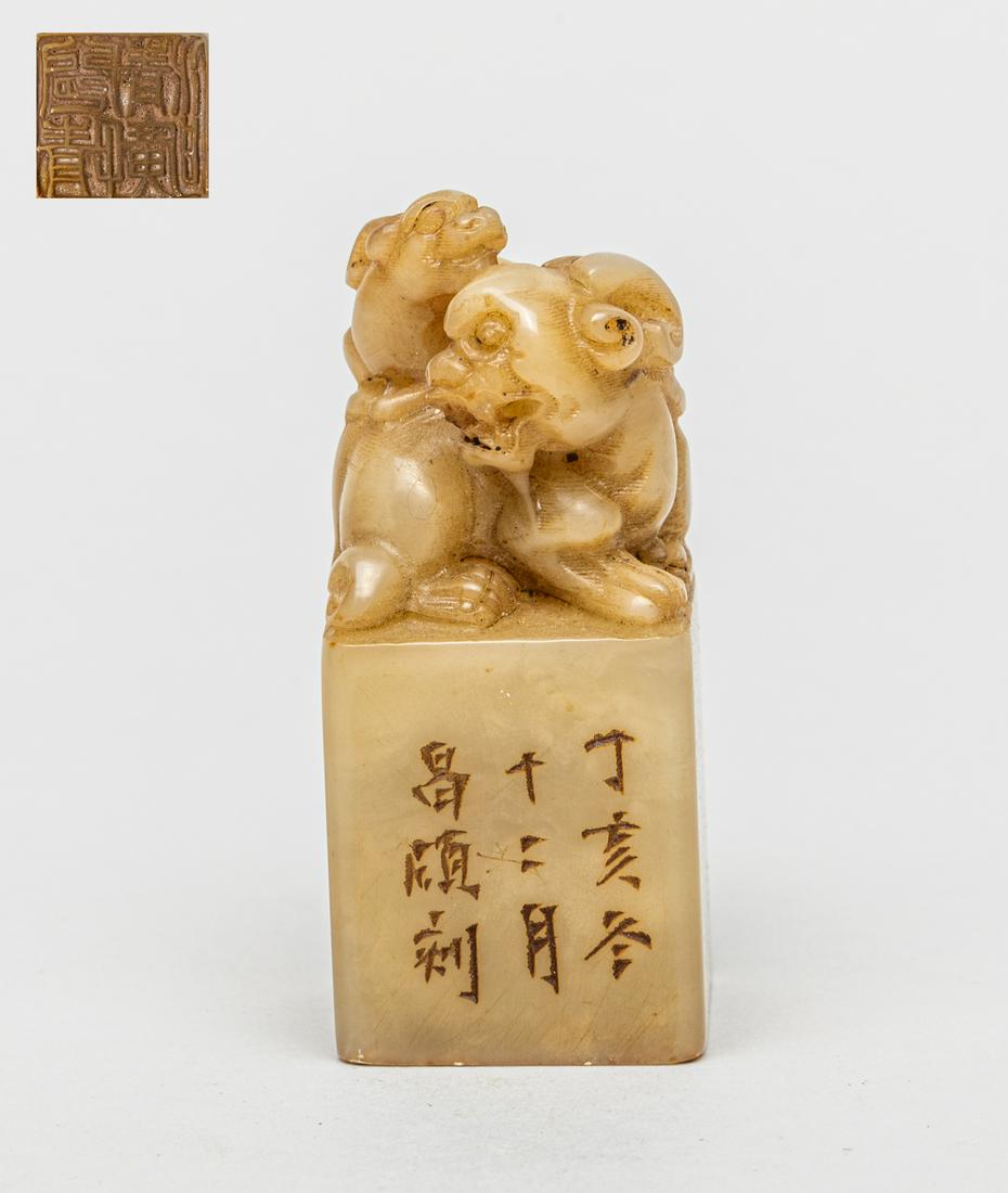 Vintage Chinese Shoushan Stone Seal: Of square section carved with a finial in the form of a recumbent mythical horned beast glancing over its right shoulder, its cub crouching on its back, one side inscribed with nine characters. 2.72in