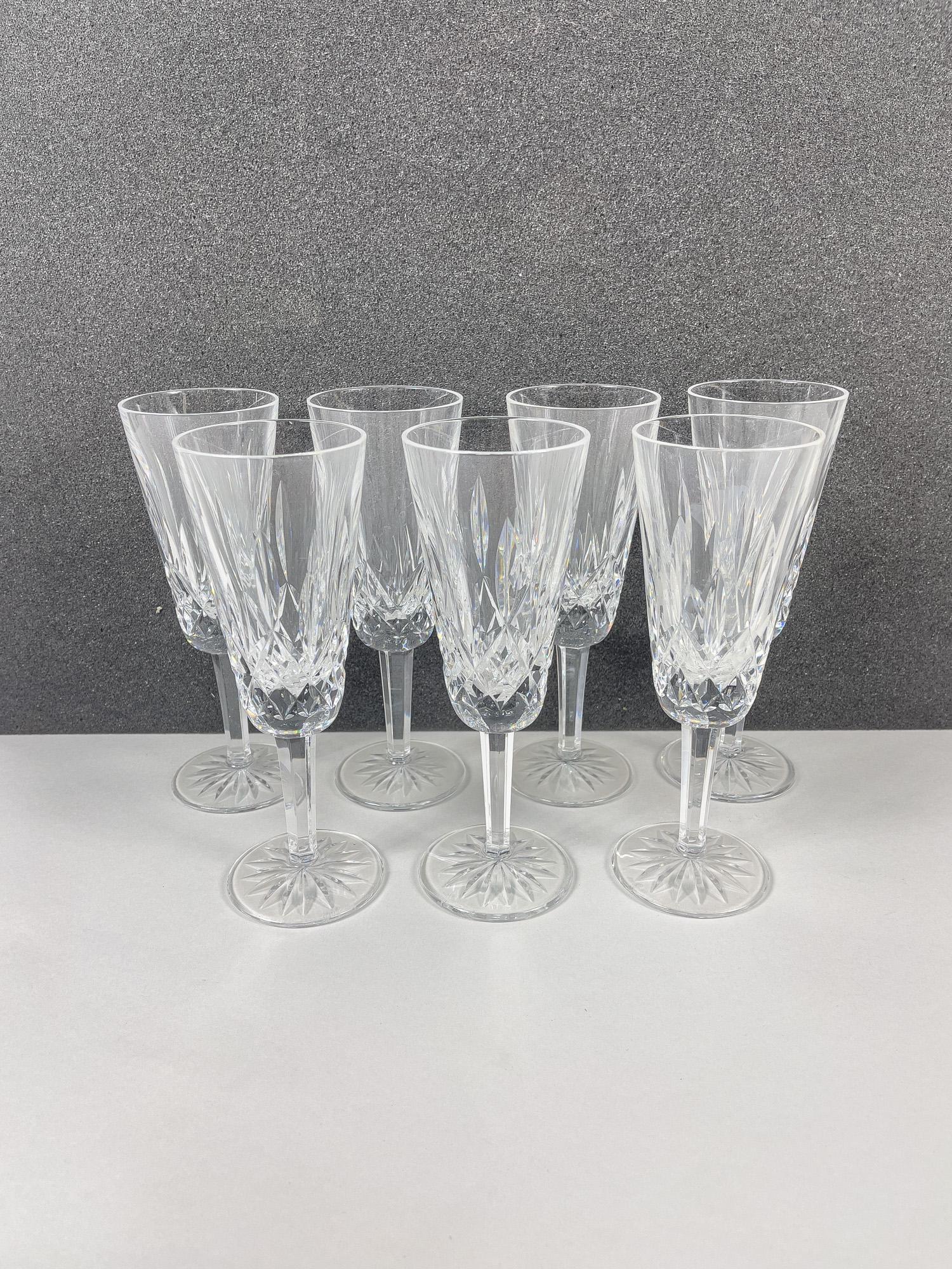 Classical Waterford Crystal Flute Wine Glasses: Set of seven clear crystal flute wine glasses, cut with classical geometrical motifs. 7.25inch H, 2.5inch W (each).