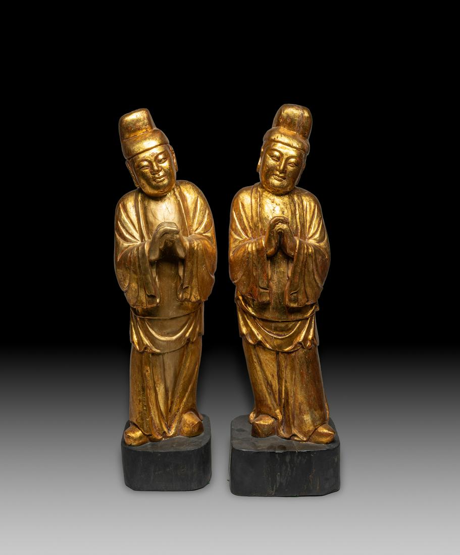 Pair Chinese Ming Type Wood Figures: Carved as standing figures dressed in long flowing robes, the hands crossing on the chest, the face with serene expression. 27.6inch H, 8inch L, 6.5inch W (larger).